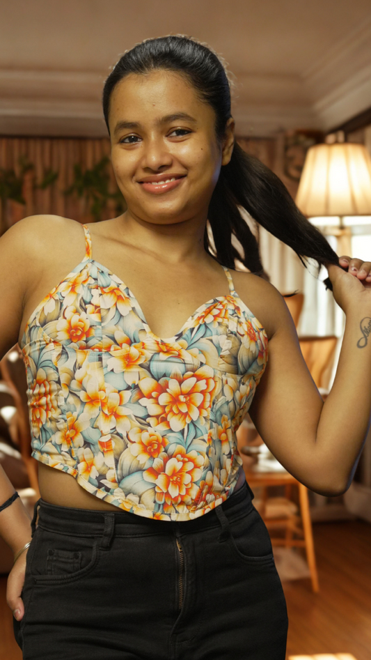 Woman wearing a floral top and black pants in a living room setting