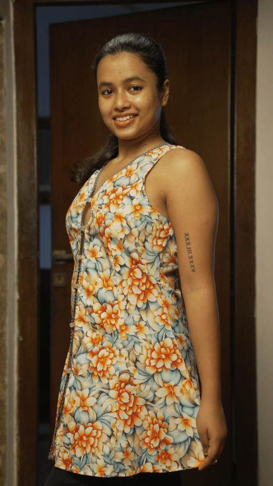 Woman wearing a floral dress standing in a doorway.