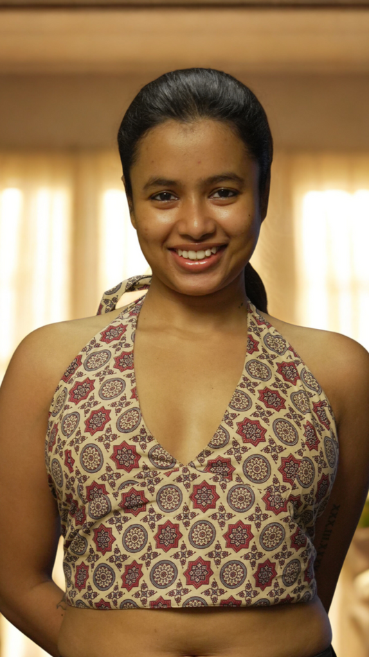 Woman wearing a patterned top with a blurred indoor background
