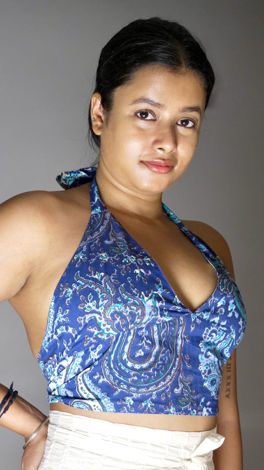 Woman wearing a blue patterned top against a gray background