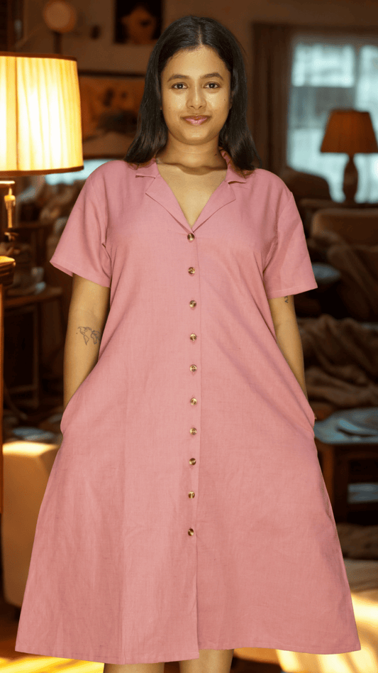 Woman wearing a pink dress in a cozy living room setting
