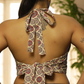 Woman wearing a floral-patterned top with a unique back design, standing indoors.