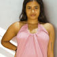 Woman wearing a pink halter neck dress against a neutral background