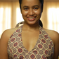 Woman wearing a patterned top with a blurred indoor background