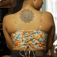 Woman wearing a floral top with a tattoo on her back in a living room setting