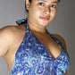 Woman wearing a blue patterned top against a gray background