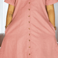 Pink dress with buttons on a plain background