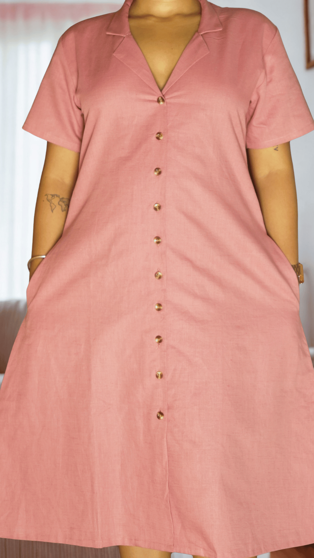 Pink dress with buttons on a plain background